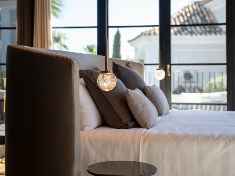 A four-bedroom villa in Nueva Andalucía with open golf and sea views, arranged over multiple levels with a garden-level pool, integrated outdoor kitchen, generous terraces and a private garage.