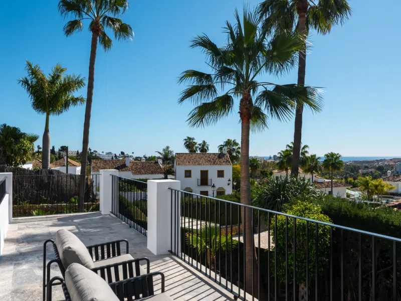 A four-bedroom villa in Nueva Andalucía with open golf and sea views, arranged over multiple levels with a garden-level pool, integrated outdoor kitchen, generous terraces and a private garage.
