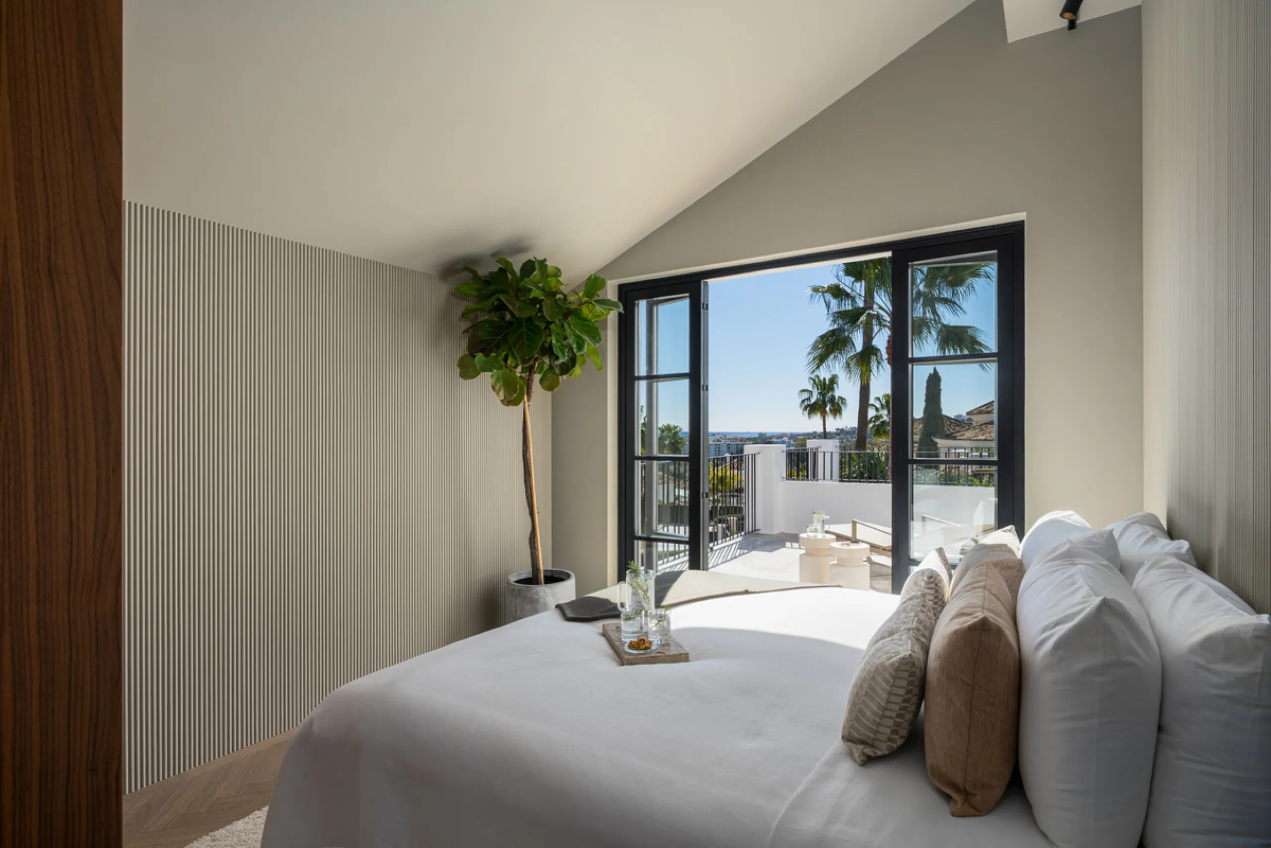A four-bedroom villa in Nueva Andalucía with open golf and sea views, arranged over multiple levels with a garden-level pool, integrated outdoor kitchen, generous terraces and a private garage.