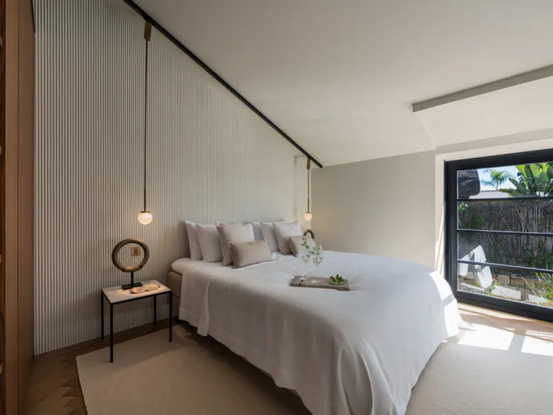 A four-bedroom villa in Nueva Andalucía with open golf and sea views, arranged over multiple levels with a garden-level pool, integrated outdoor kitchen, generous terraces and a private garage.
