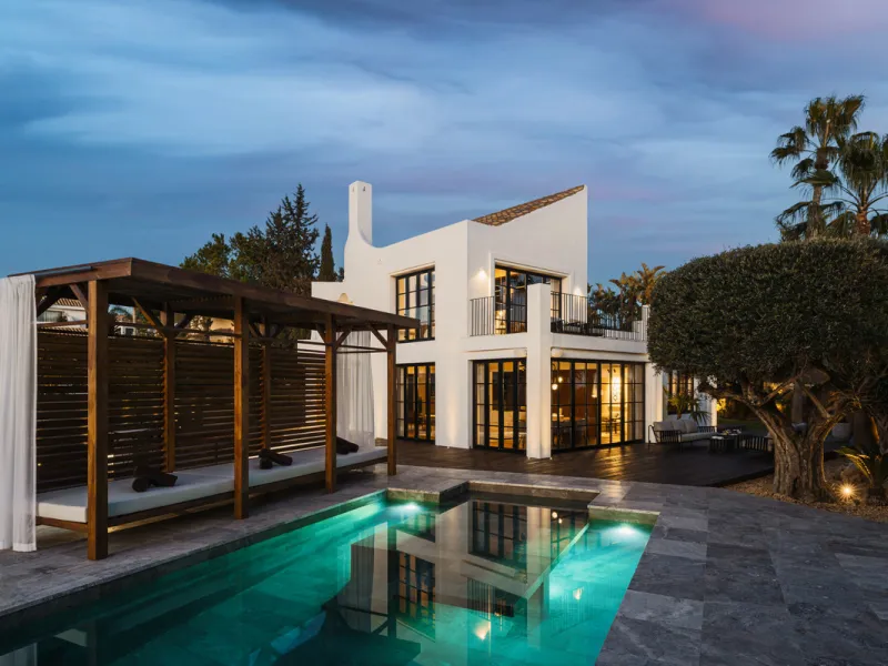 A four-bedroom villa in Nueva Andalucía with open golf and sea views, arranged over multiple levels with a garden-level pool, integrated outdoor kitchen, generous terraces and a private garage.