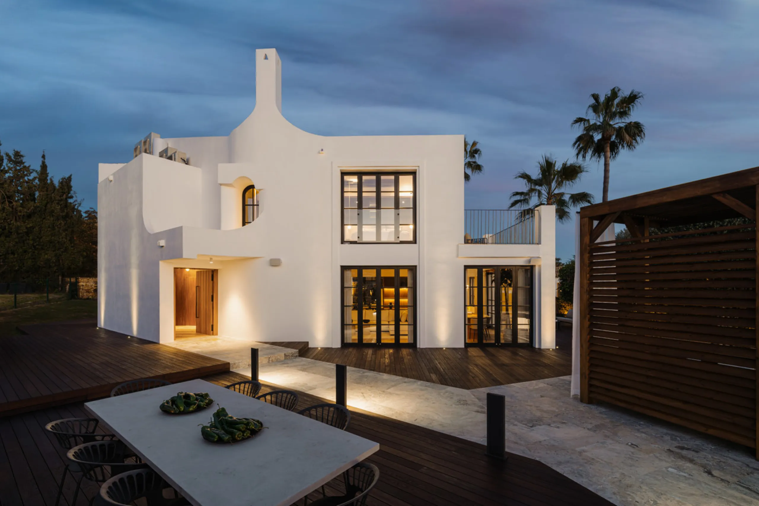 A four-bedroom villa in Nueva Andalucía with open golf and sea views, arranged over multiple levels with a garden-level pool, integrated outdoor kitchen, generous terraces and a private garage.