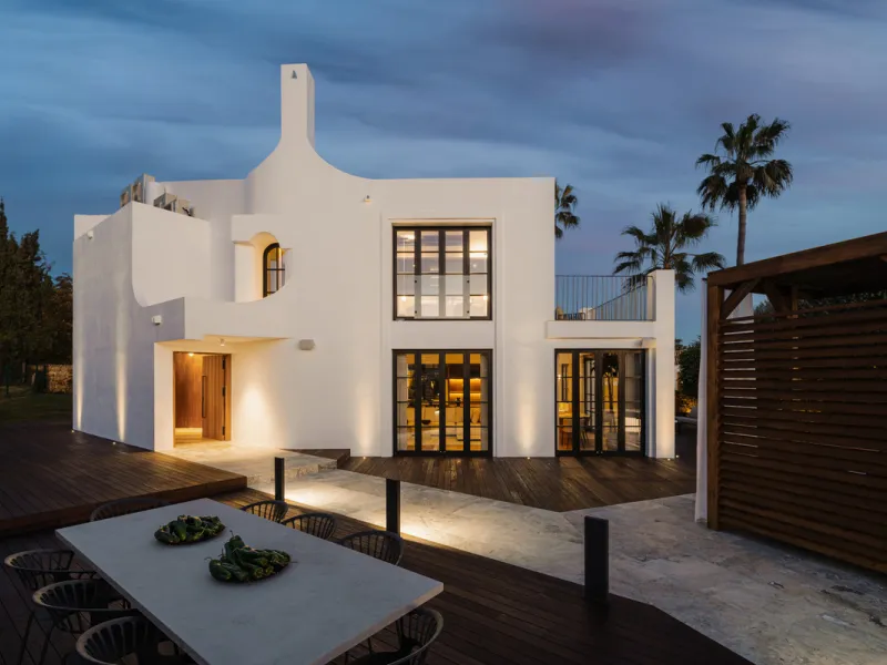 A four-bedroom villa in Nueva Andalucía with open golf and sea views, arranged over multiple levels with a garden-level pool, integrated outdoor kitchen, generous terraces and a private garage.