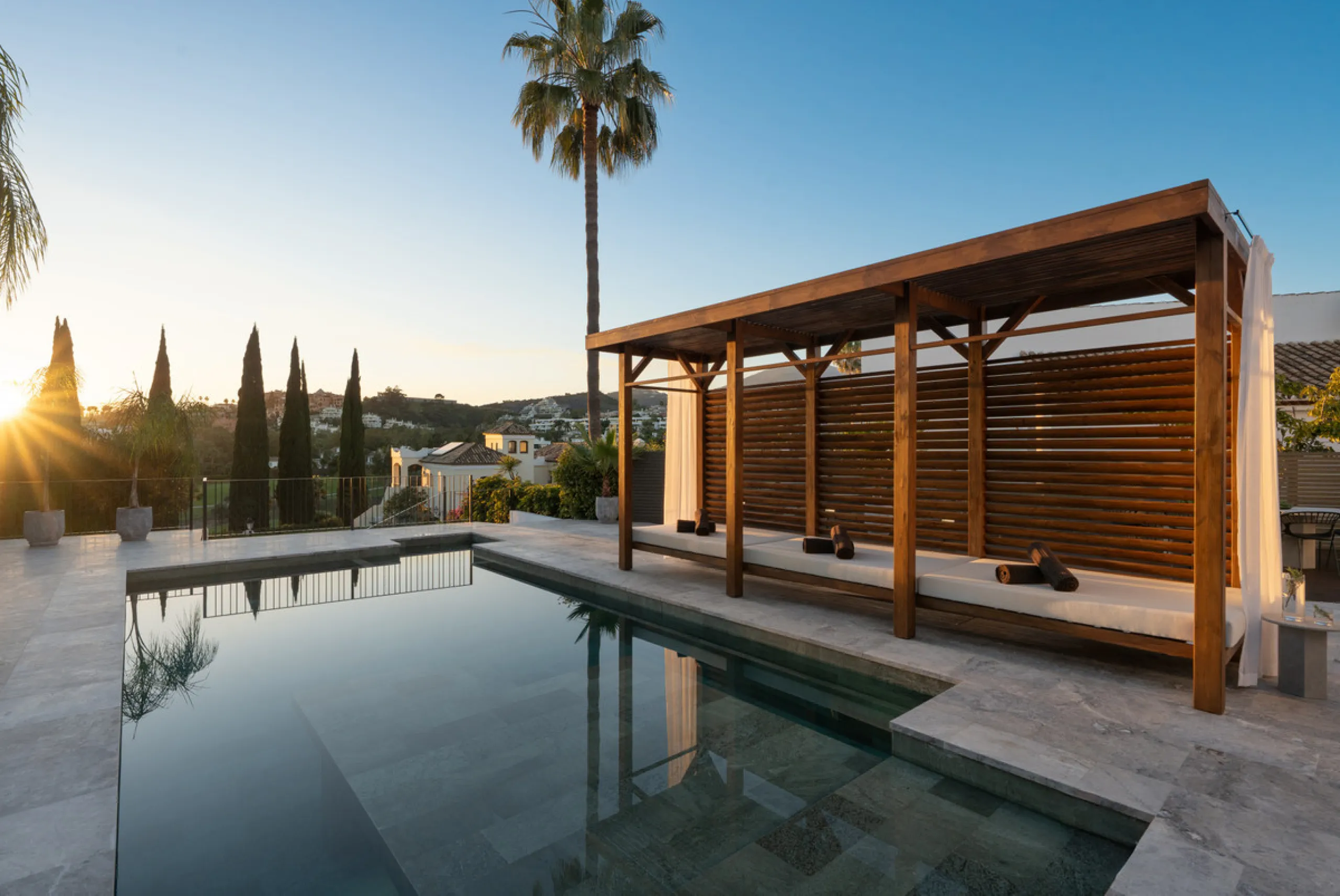 A four-bedroom villa in Nueva Andalucía with open golf and sea views, arranged over multiple levels with a garden-level pool, integrated outdoor kitchen, generous terraces and a private garage.