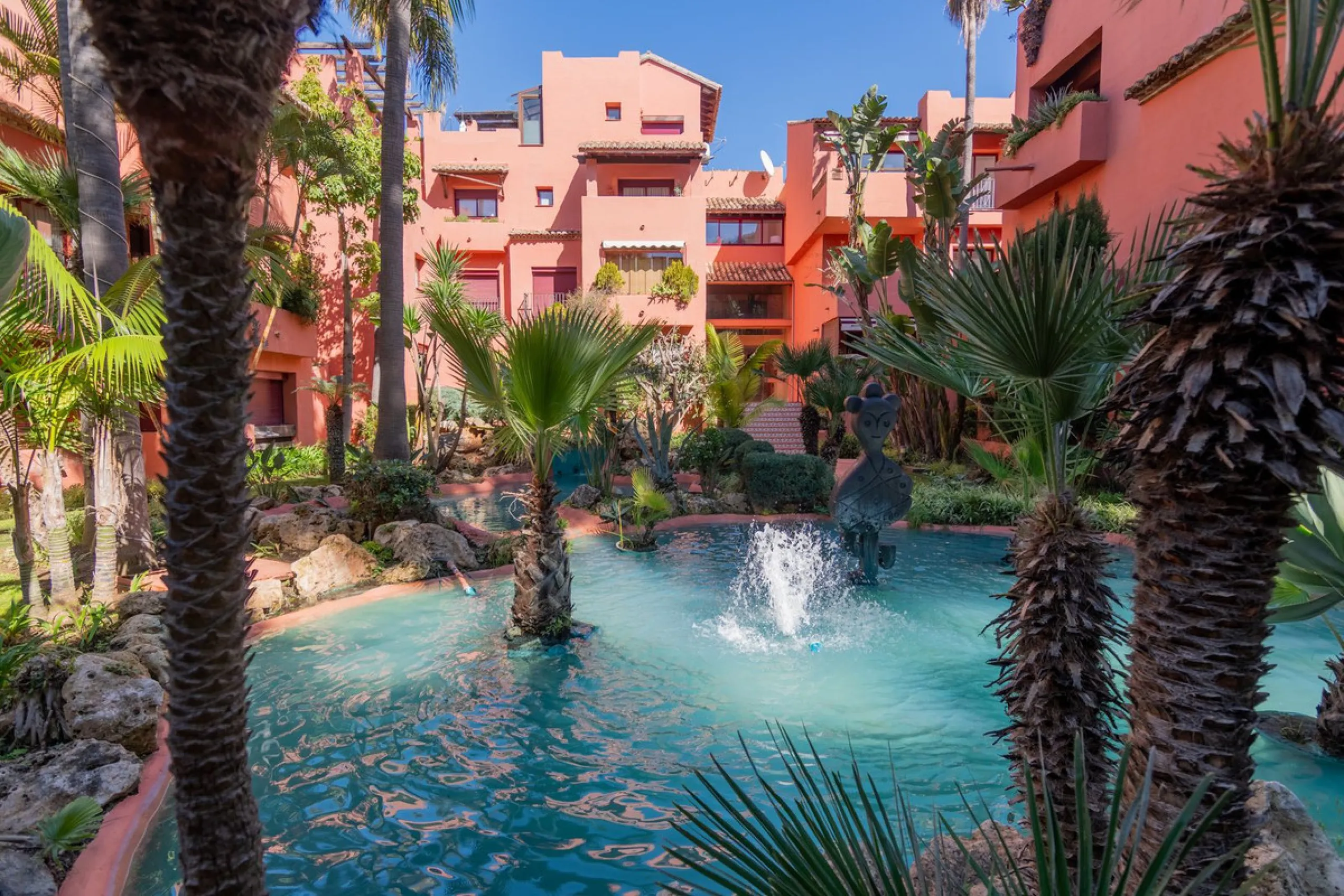 An apartment with 3 bedrooms, 2 bathrooms, a spacious living room, and a new kitchen with a dining area overlooking a beautiful garden with a fountain. The property is located in a unique, lush residential community where the views from the terrace and wi