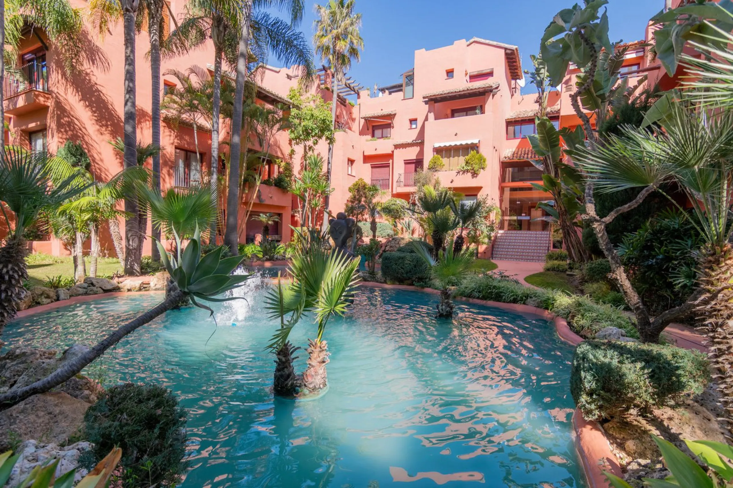 An apartment with 3 bedrooms, 2 bathrooms, a spacious living room, and a new kitchen with a dining area overlooking a beautiful garden with a fountain. The property is located in a unique, lush residential community where the views from the terrace and wi