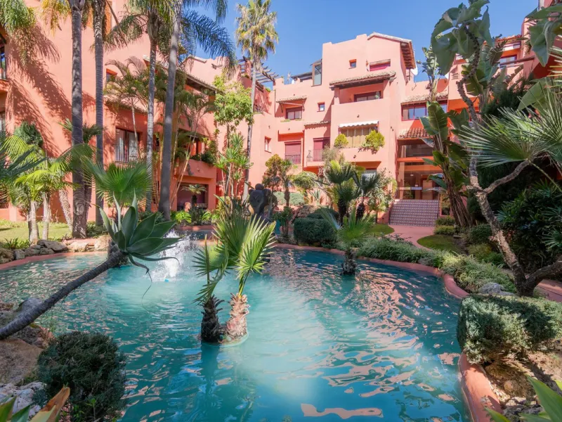 An apartment with 3 bedrooms, 2 bathrooms, a spacious living room, and a new kitchen with a dining area overlooking a beautiful garden with a fountain. The property is located in a unique, lush residential community where the views from the terrace and wi