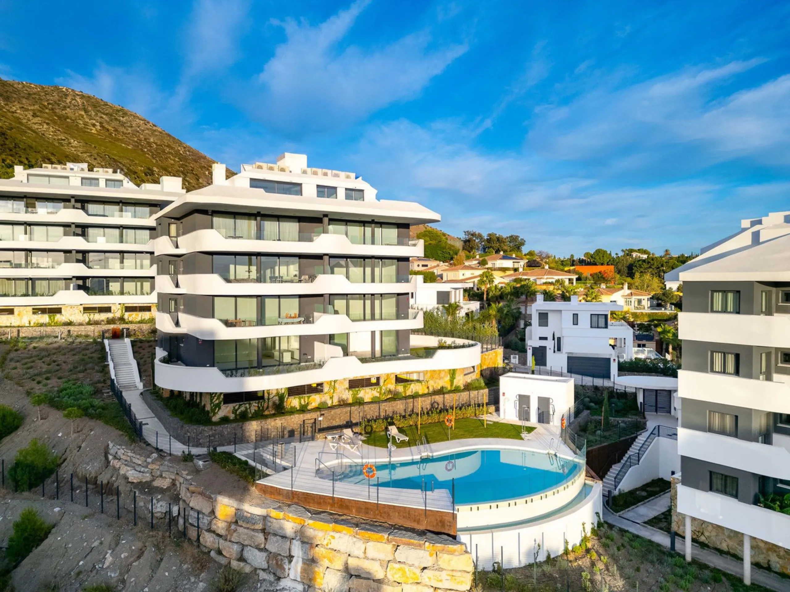 Welcome to a beautifully positioned southwest-facing garden apartment in the heart of Higuerón — a home that offers both privacy and extraordinary views. Located on the eastern corner of the building, this residence is one of only two ground-floor apartme