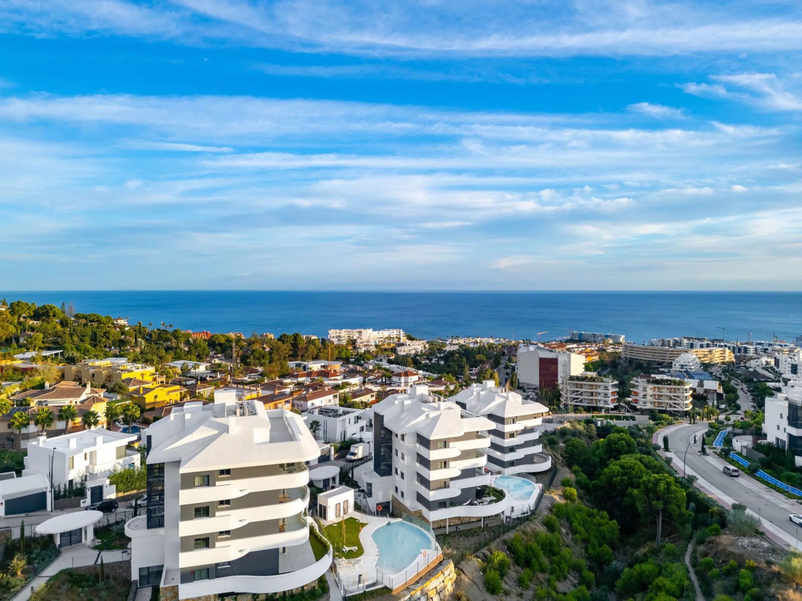 Welcome to a beautifully positioned southwest-facing garden apartment in the heart of Higuerón — a home that offers both privacy and extraordinary views. Located on the eastern corner of the building, this residence is one of only two ground-floor apartme