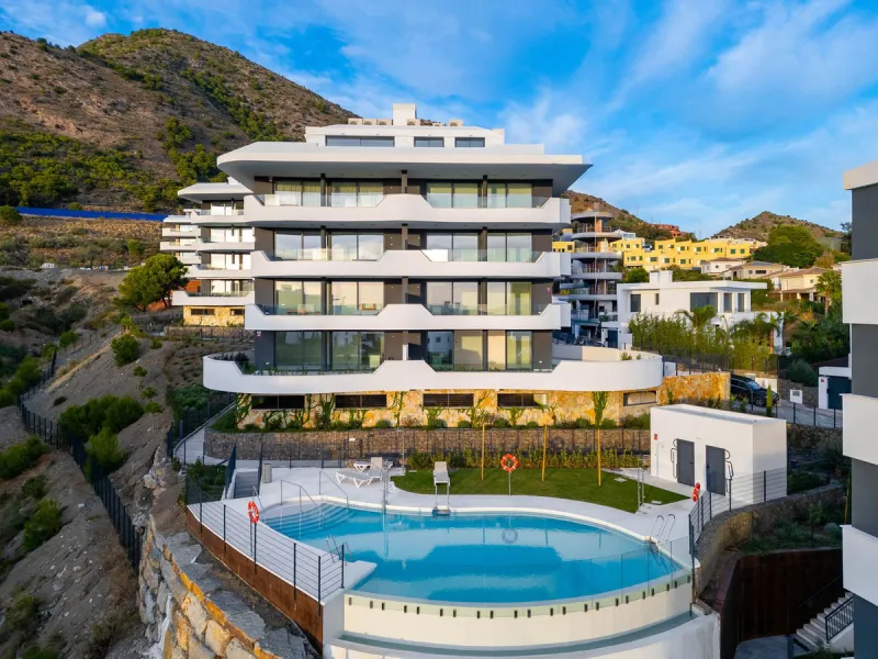 Welcome to a beautifully positioned southwest-facing garden apartment in the heart of Higuerón — a home that offers both privacy and extraordinary views. Located on the eastern corner of the building, this residence is one of only two ground-floor apartme
