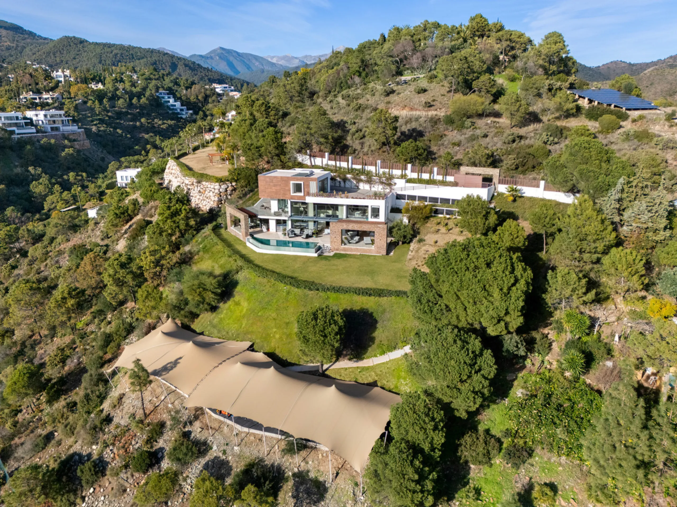 A five-bedroom villa in El Madroñal, Benahavís, offering five bathrooms plus a guest cloakroom, with a first floor dedicated to the master suite with dressing room and library alongside a guest ensuite, a ground floor arranged around formal and informal l