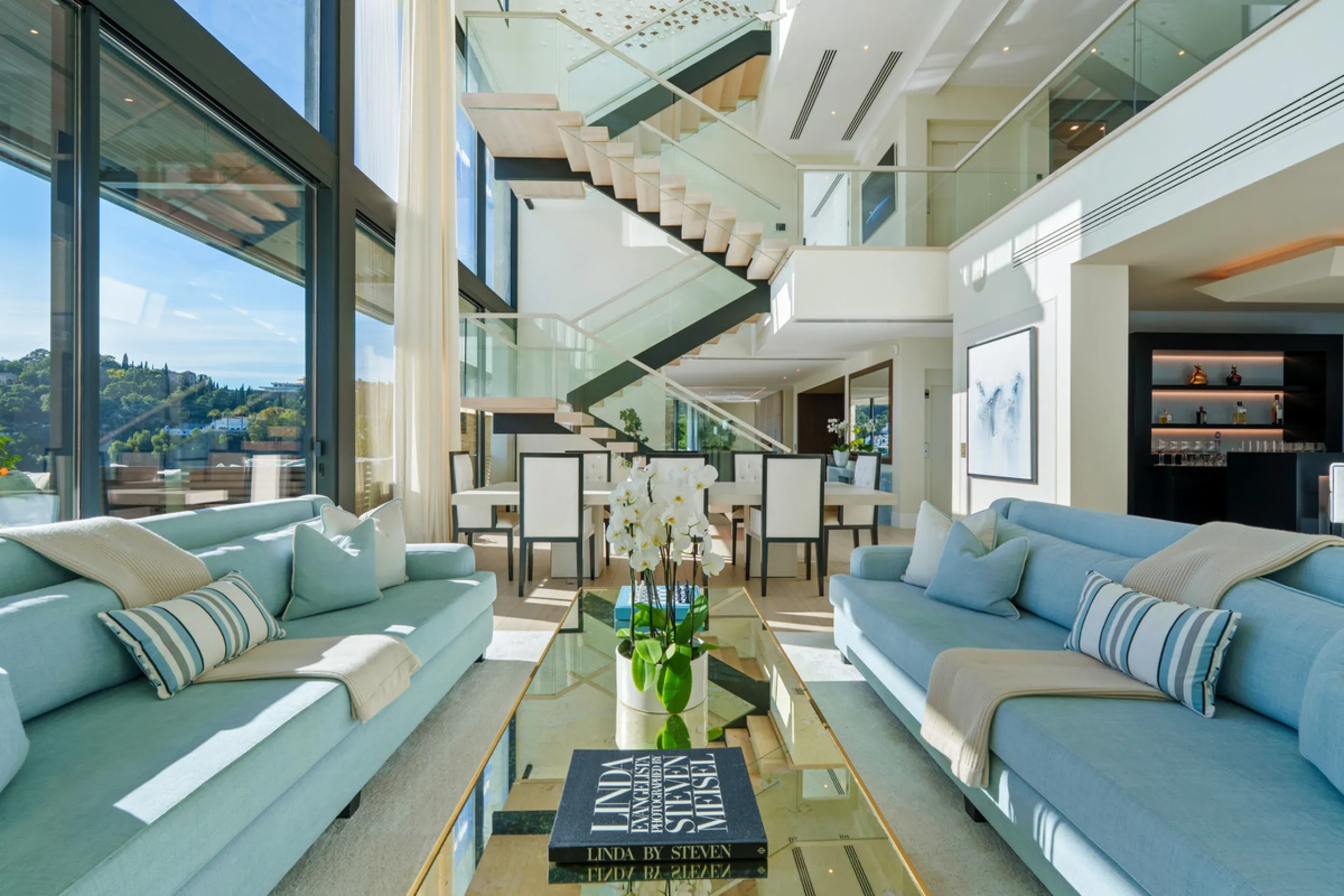 A five-bedroom villa in El Madroñal, Benahavís, offering five bathrooms plus a guest cloakroom, with a first floor dedicated to the master suite with dressing room and library alongside a guest ensuite, a ground floor arranged around formal and informal l