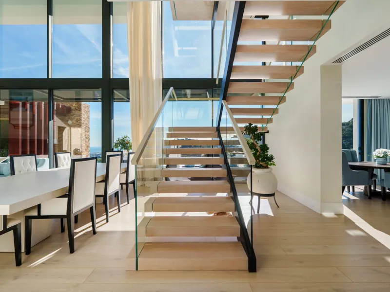 A five-bedroom villa in El Madroñal, Benahavís, offering five bathrooms plus a guest cloakroom, with a first floor dedicated to the master suite with dressing room and library alongside a guest ensuite, a ground floor arranged around formal and informal l