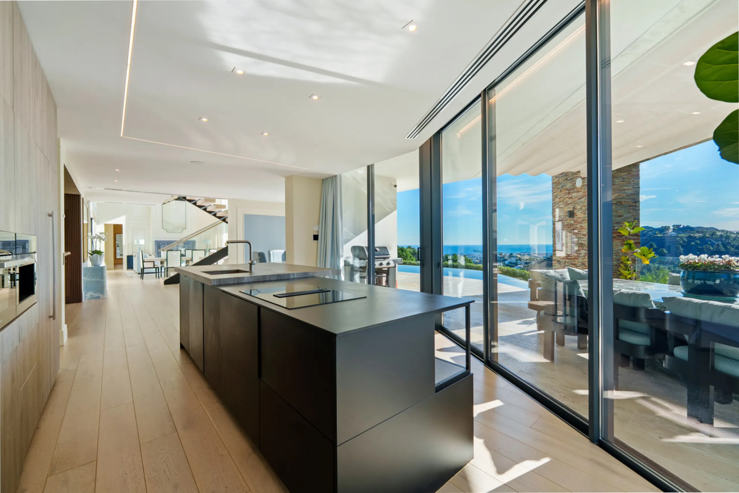 A five-bedroom villa in El Madroñal, Benahavís, offering five bathrooms plus a guest cloakroom, with a first floor dedicated to the master suite with dressing room and library alongside a guest ensuite, a ground floor arranged around formal and informal l