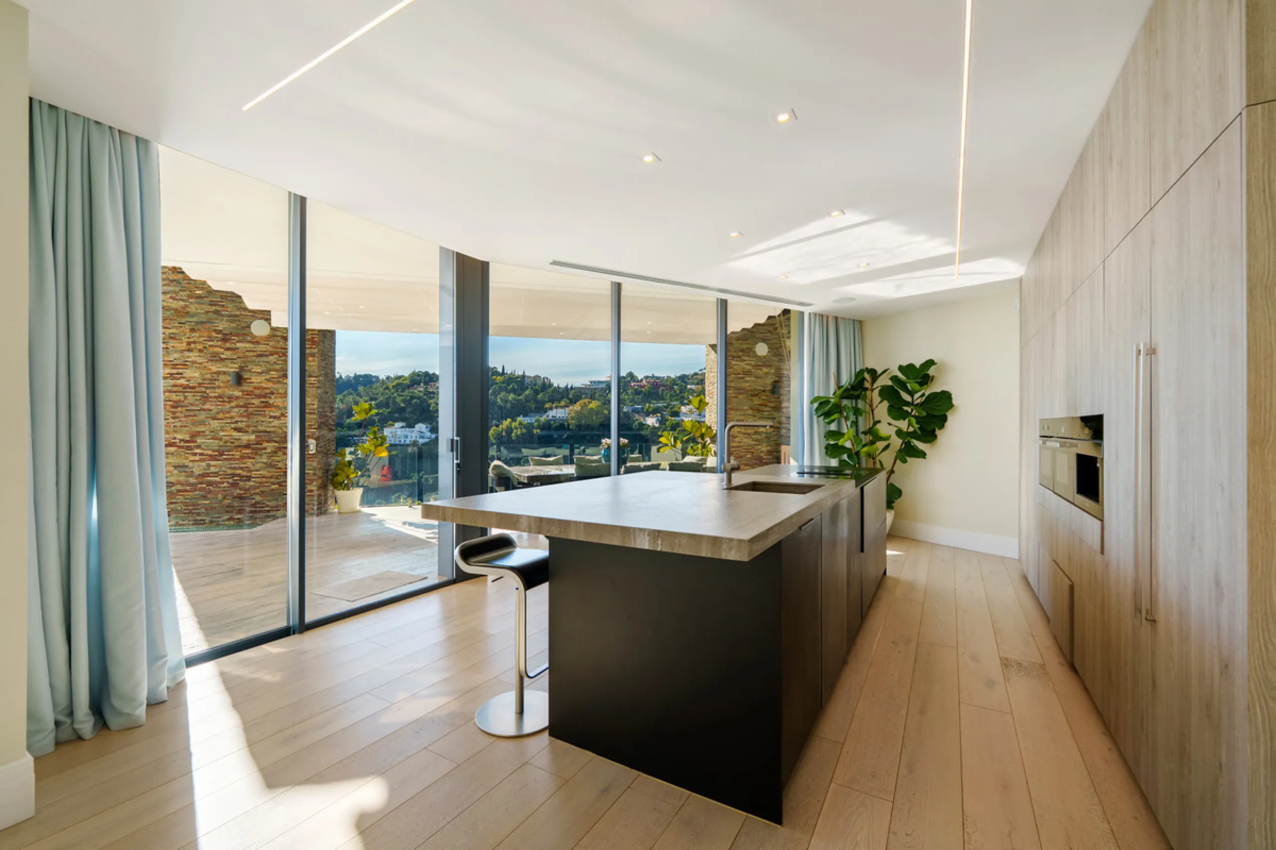 A five-bedroom villa in El Madroñal, Benahavís, offering five bathrooms plus a guest cloakroom, with a first floor dedicated to the master suite with dressing room and library alongside a guest ensuite, a ground floor arranged around formal and informal l