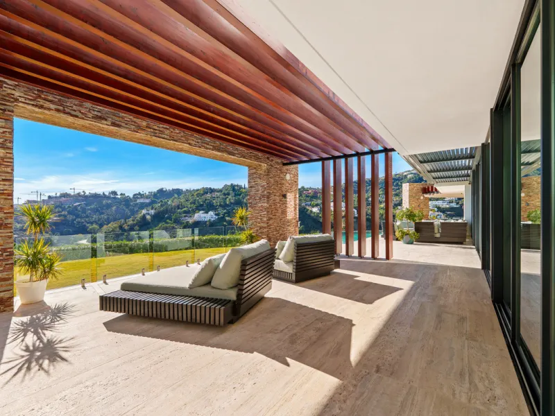 A five-bedroom villa in El Madroñal, Benahavís, offering five bathrooms plus a guest cloakroom, with a first floor dedicated to the master suite with dressing room and library alongside a guest ensuite, a ground floor arranged around formal and informal l