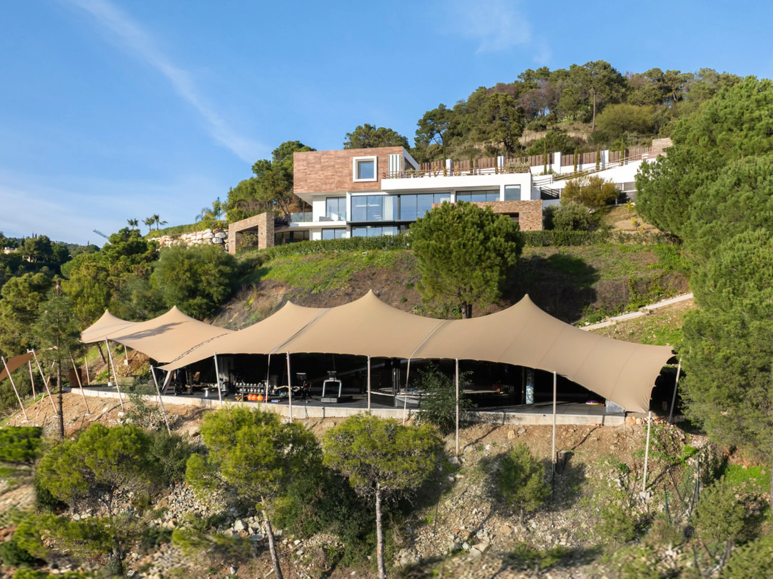 A five-bedroom villa in El Madroñal, Benahavís, offering five bathrooms plus a guest cloakroom, with a first floor dedicated to the master suite with dressing room and library alongside a guest ensuite, a ground floor arranged around formal and informal l