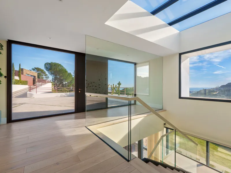 A five-bedroom villa in El Madroñal, Benahavís, offering five bathrooms plus a guest cloakroom, with a first floor dedicated to the master suite with dressing room and library alongside a guest ensuite, a ground floor arranged around formal and informal l