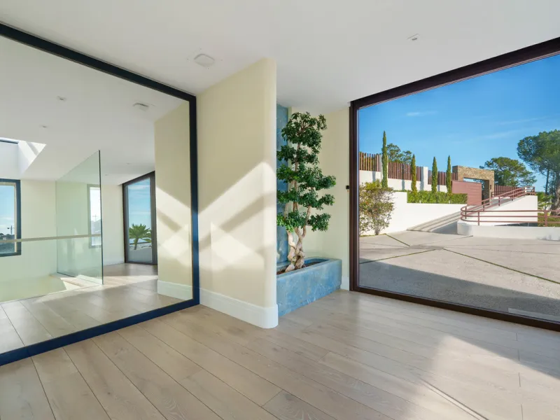 A five-bedroom villa in El Madroñal, Benahavís, offering five bathrooms plus a guest cloakroom, with a first floor dedicated to the master suite with dressing room and library alongside a guest ensuite, a ground floor arranged around formal and informal l