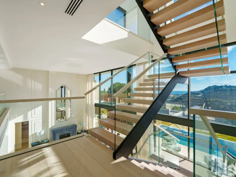 A five-bedroom villa in El Madroñal, Benahavís, offering five bathrooms plus a guest cloakroom, with a first floor dedicated to the master suite with dressing room and library alongside a guest ensuite, a ground floor arranged around formal and informal l