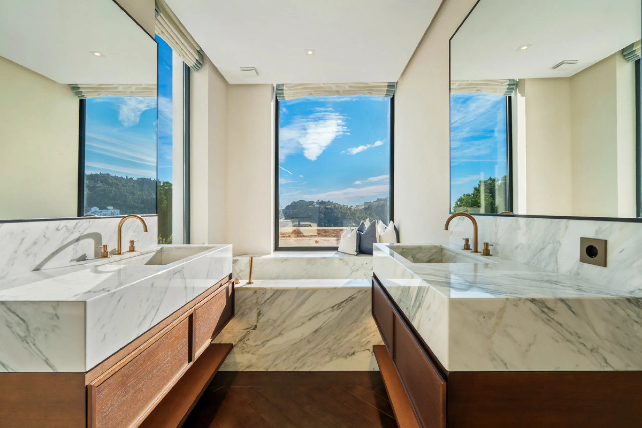 A five-bedroom villa in El Madroñal, Benahavís, offering five bathrooms plus a guest cloakroom, with a first floor dedicated to the master suite with dressing room and library alongside a guest ensuite, a ground floor arranged around formal and informal l