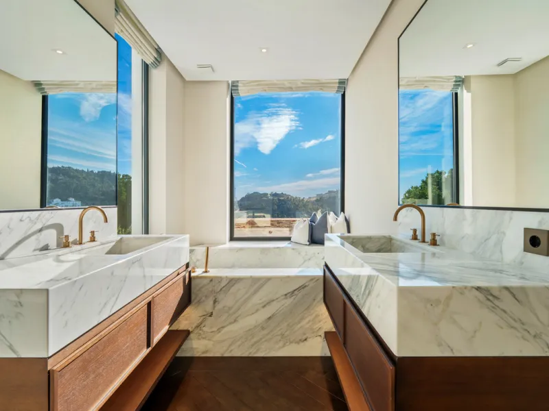A five-bedroom villa in El Madroñal, Benahavís, offering five bathrooms plus a guest cloakroom, with a first floor dedicated to the master suite with dressing room and library alongside a guest ensuite, a ground floor arranged around formal and informal l
