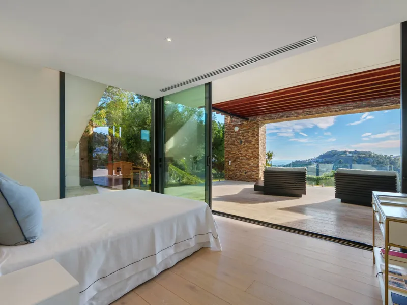 A five-bedroom villa in El Madroñal, Benahavís, offering five bathrooms plus a guest cloakroom, with a first floor dedicated to the master suite with dressing room and library alongside a guest ensuite, a ground floor arranged around formal and informal l
