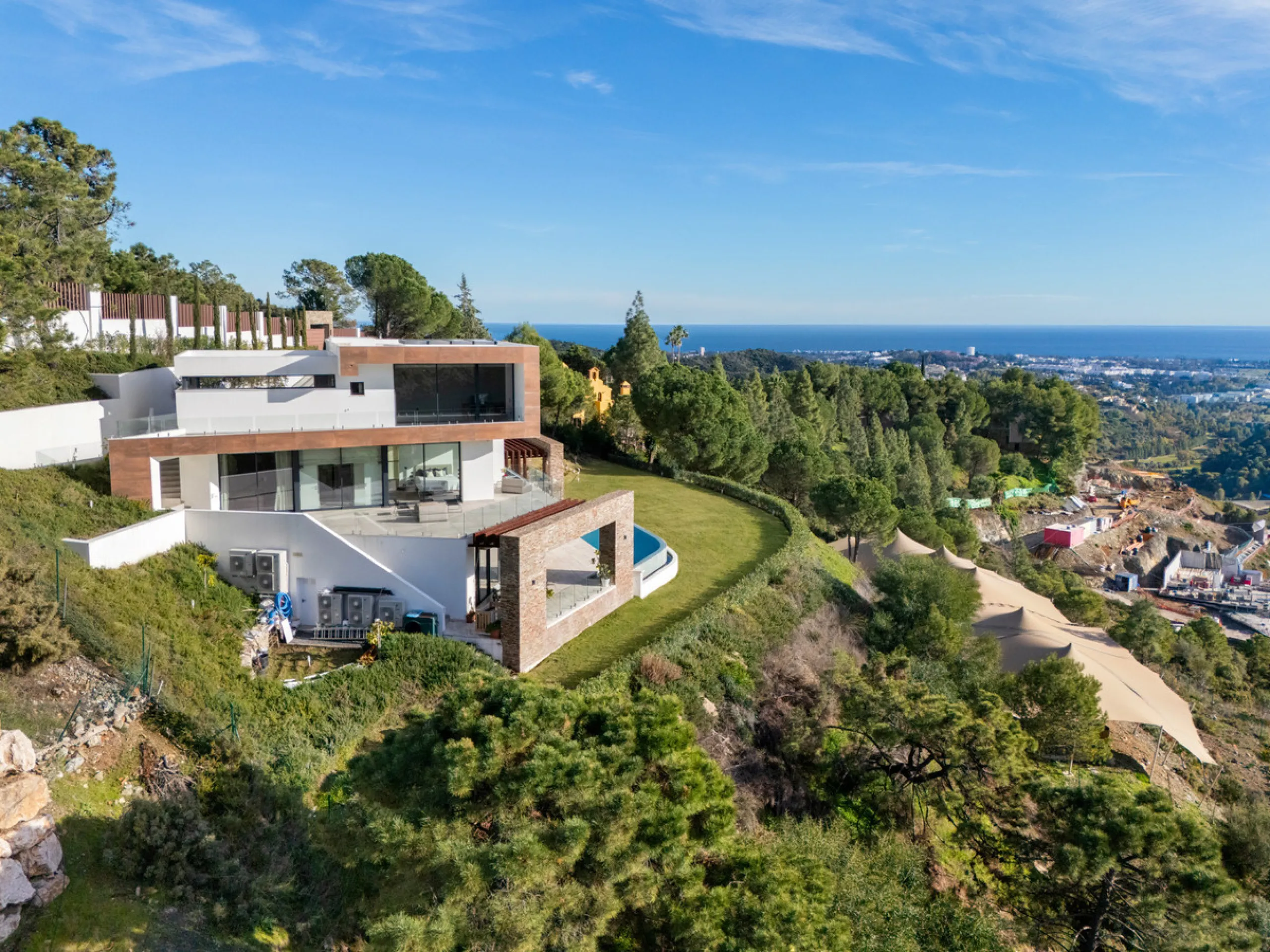 A five-bedroom villa in El Madroñal, Benahavís, offering five bathrooms plus a guest cloakroom, with a first floor dedicated to the master suite with dressing room and library alongside a guest ensuite, a ground floor arranged around formal and informal l