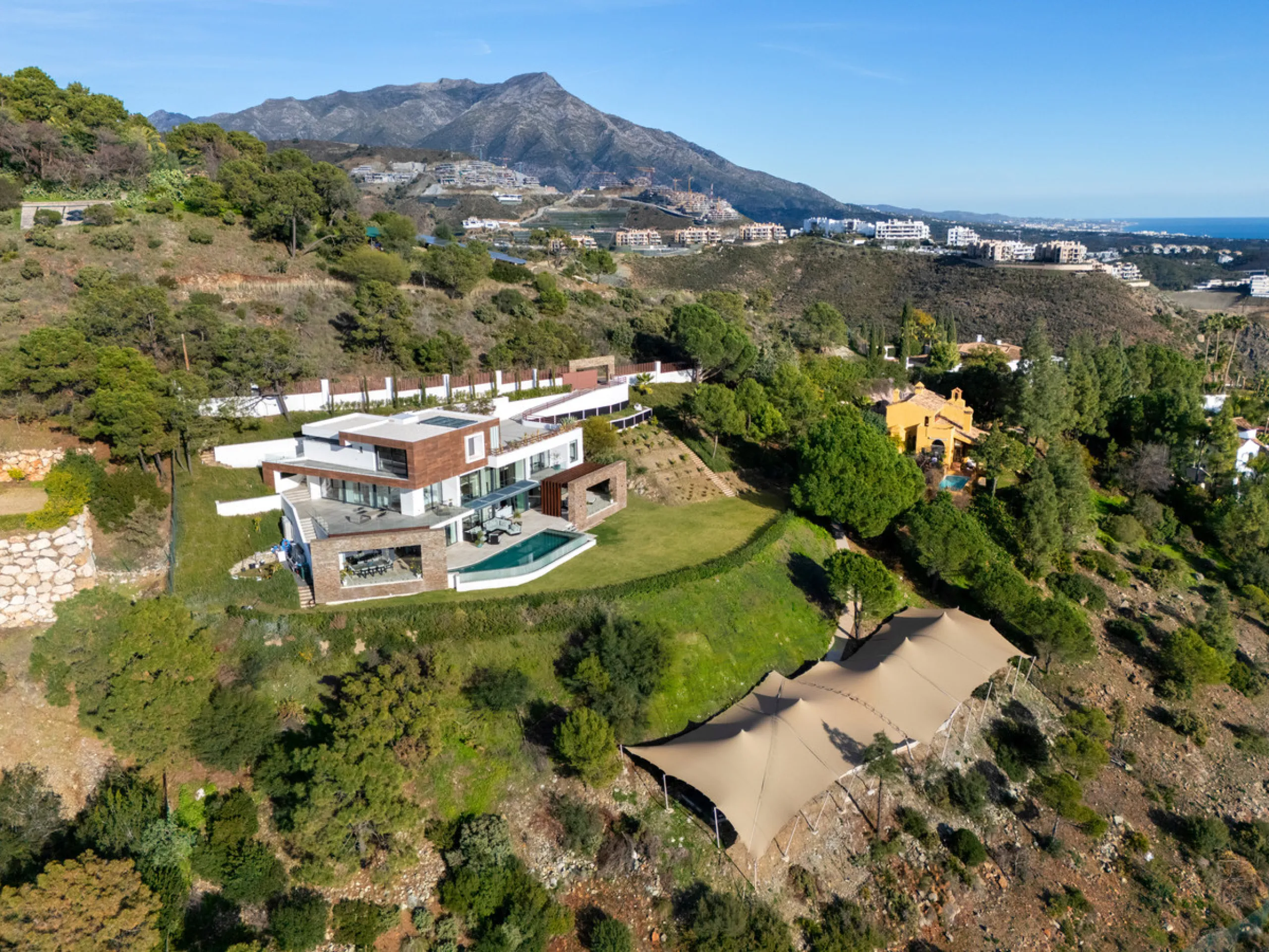 A five-bedroom villa in El Madroñal, Benahavís, offering five bathrooms plus a guest cloakroom, with a first floor dedicated to the master suite with dressing room and library alongside a guest ensuite, a ground floor arranged around formal and informal l