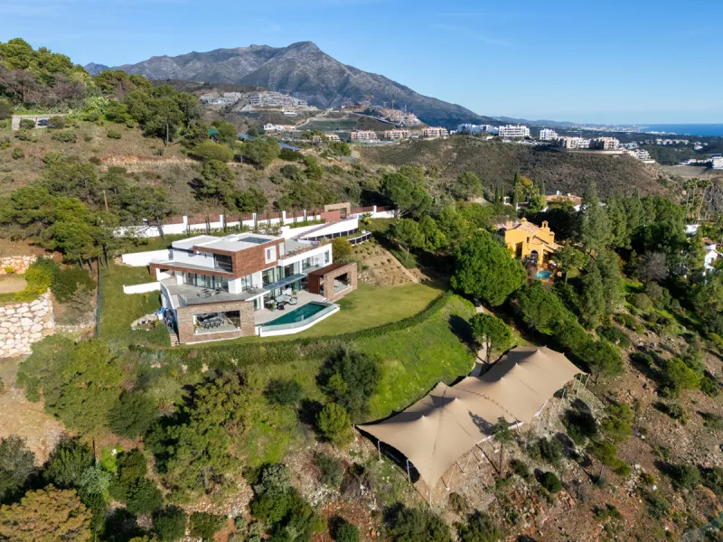 A five-bedroom villa in El Madroñal, Benahavís, offering five bathrooms plus a guest cloakroom, with a first floor dedicated to the master suite with dressing room and library alongside a guest ensuite, a ground floor arranged around formal and informal l