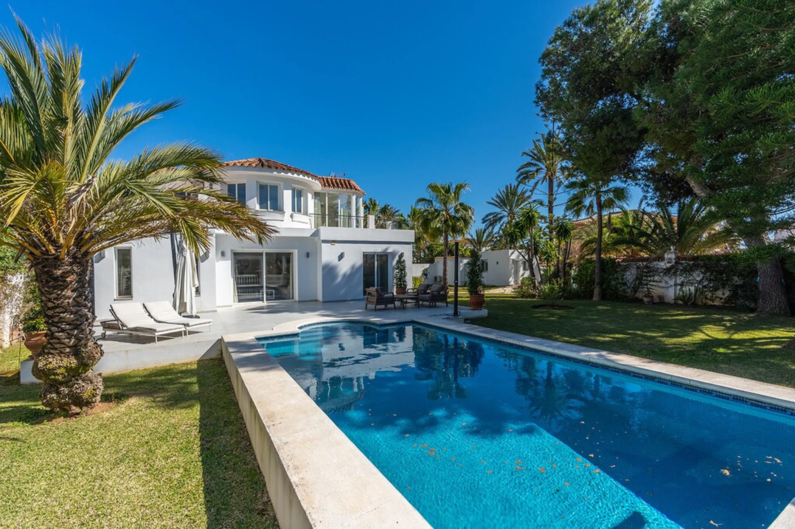 Just 50 metres from the beach, this beautifully renovated and modernised four bedroom, three bathroom villa is set on a spacious, flat plot featuring a large swimming pool and lush mature garden. The property boasts a fully upgraded kitchen and bathrooms,