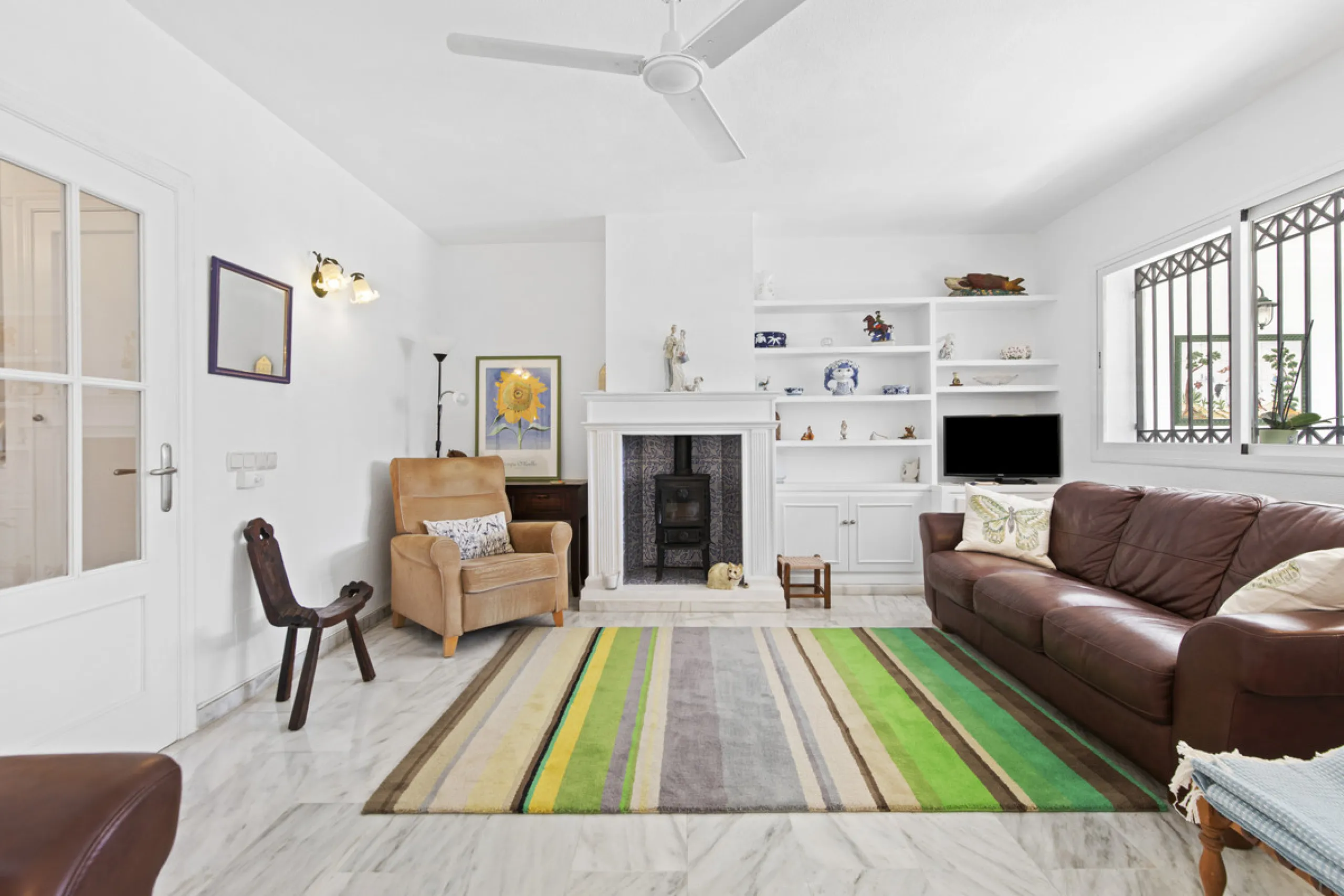 This charming two-level property offers spacious and versatile accommodation, finished to a high standard and filled with natural light throughout. The large living room is a welcoming focal point, featuring marble flooring, a beamed ceiling, a wood-burni