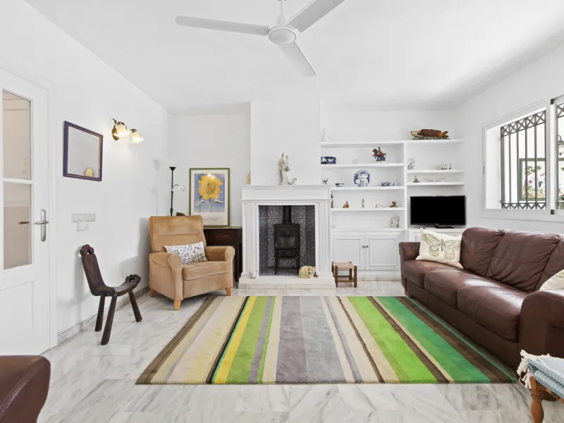 This charming two-level property offers spacious and versatile accommodation, finished to a high standard and filled with natural light throughout. The large living room is a welcoming focal point, featuring marble flooring, a beamed ceiling, a wood-burni