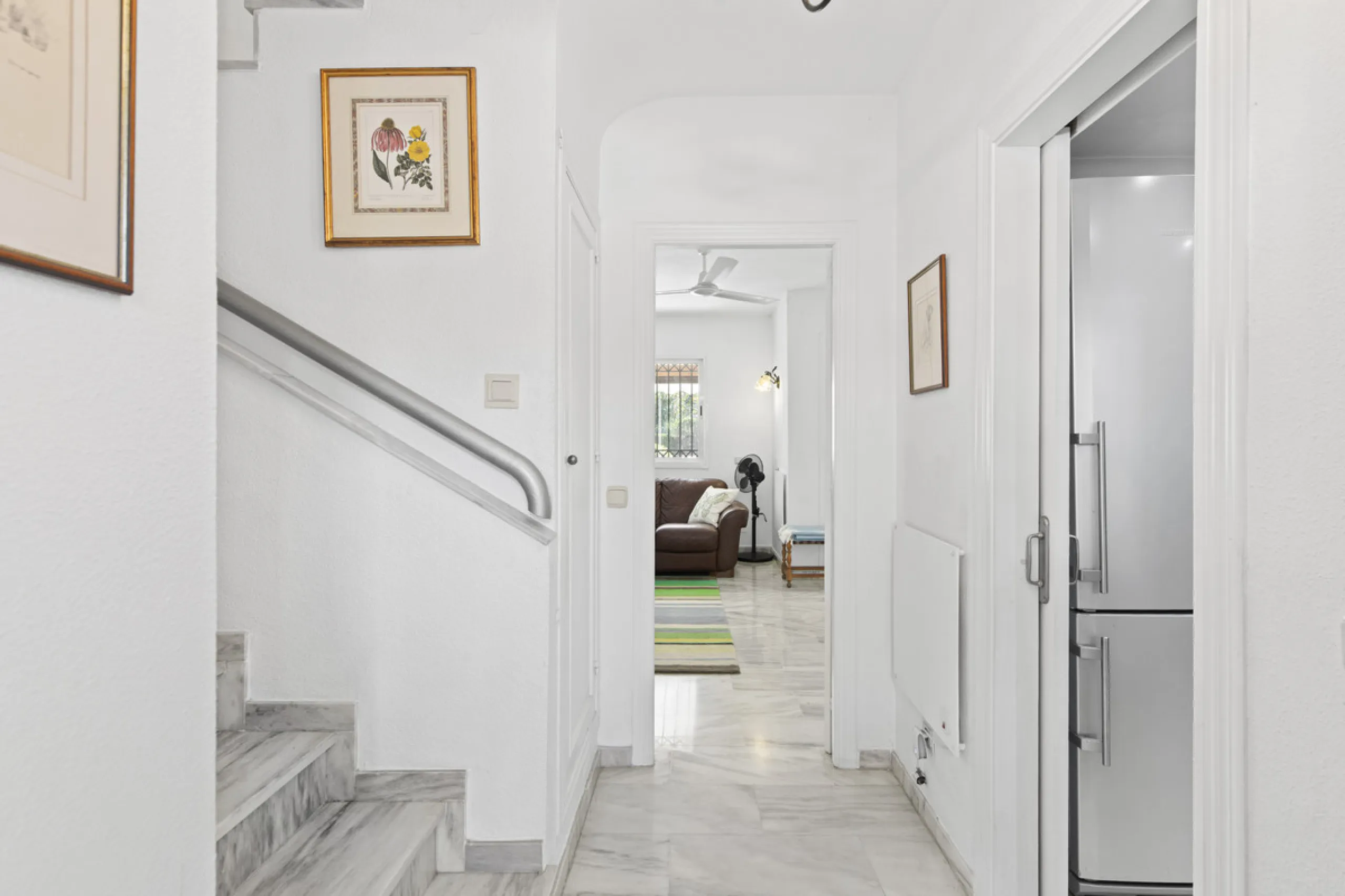 This charming two-level property offers spacious and versatile accommodation, finished to a high standard and filled with natural light throughout. The large living room is a welcoming focal point, featuring marble flooring, a beamed ceiling, a wood-burni