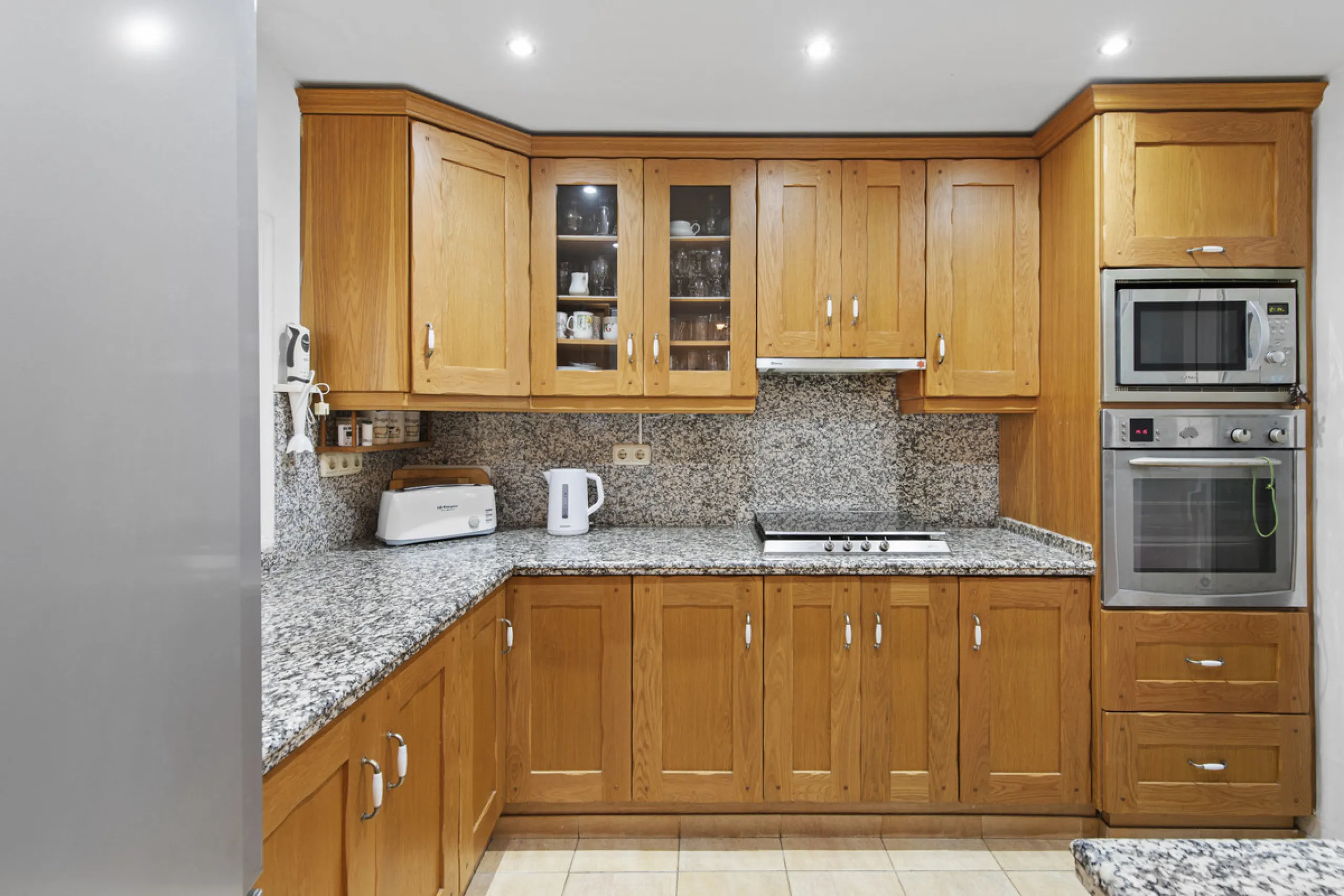 This charming two-level property offers spacious and versatile accommodation, finished to a high standard and filled with natural light throughout. The large living room is a welcoming focal point, featuring marble flooring, a beamed ceiling, a wood-burni
