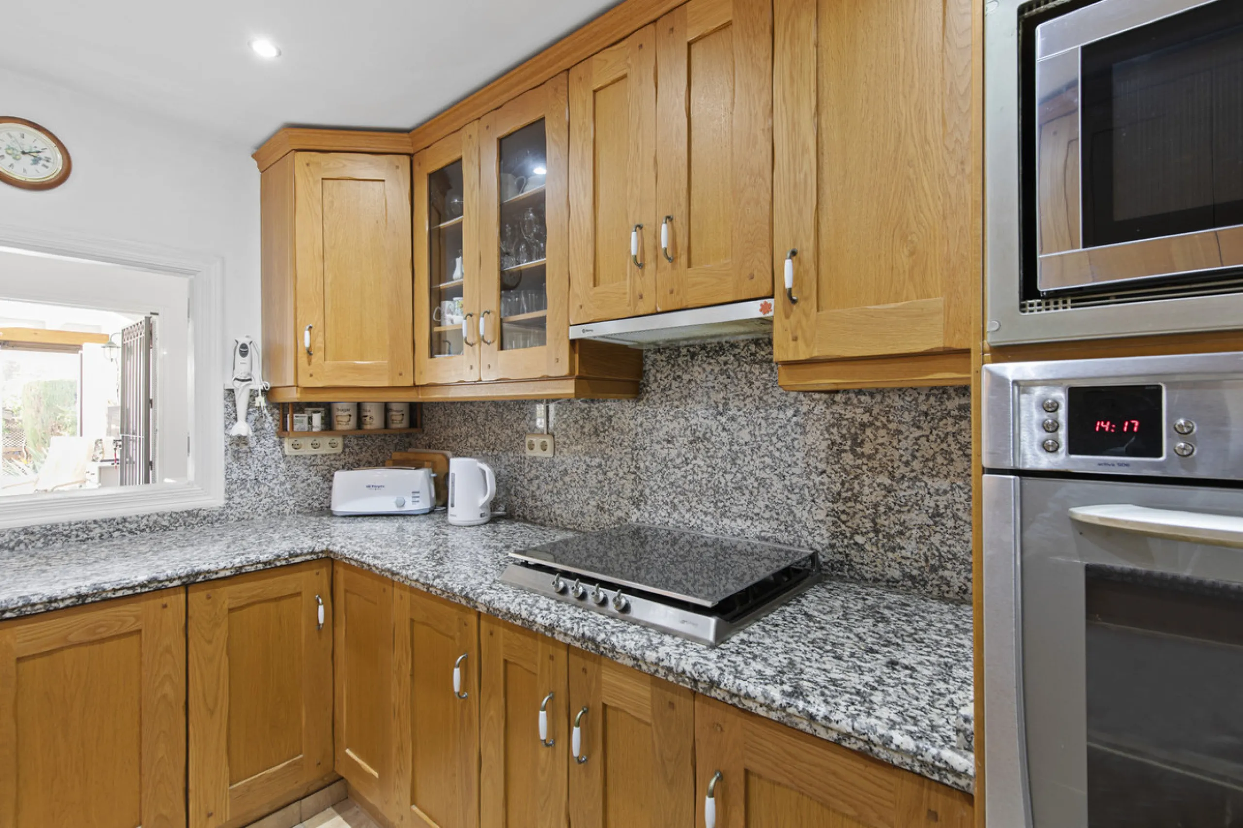 This charming two-level property offers spacious and versatile accommodation, finished to a high standard and filled with natural light throughout. The large living room is a welcoming focal point, featuring marble flooring, a beamed ceiling, a wood-burni