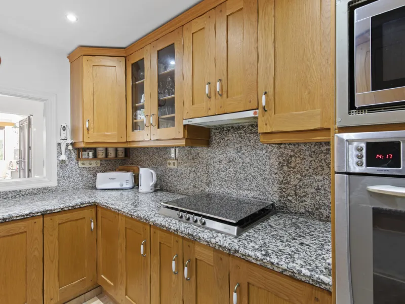 This charming two-level property offers spacious and versatile accommodation, finished to a high standard and filled with natural light throughout. The large living room is a welcoming focal point, featuring marble flooring, a beamed ceiling, a wood-burni