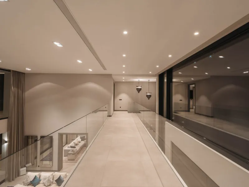 Designed by a distinguished architect, this villa is spread over two levels with an impressive built area. It features five luxurious bedrooms, each with its ensuite bathroom, an additional guest toilet, and a guest apartment that matches the main villa's