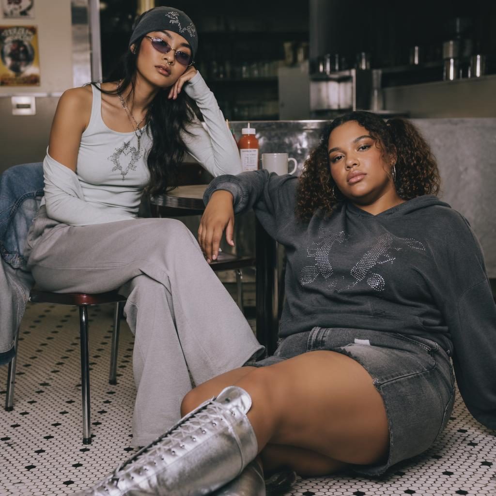 Editorial fashion model in a vintage cafe wearing a shrimp and grits clothing catalog look with a cool gray Y2K style.