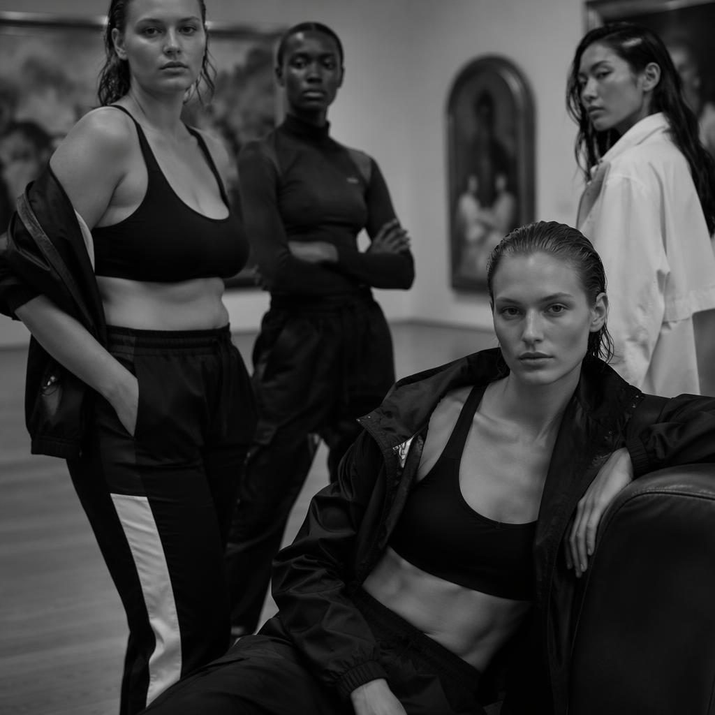 Editorial-Modefoto eines Models in sportlichem Look in einer Kunstgalerie, mit luxuriöser Stimmung und kontrastreichen Farben.