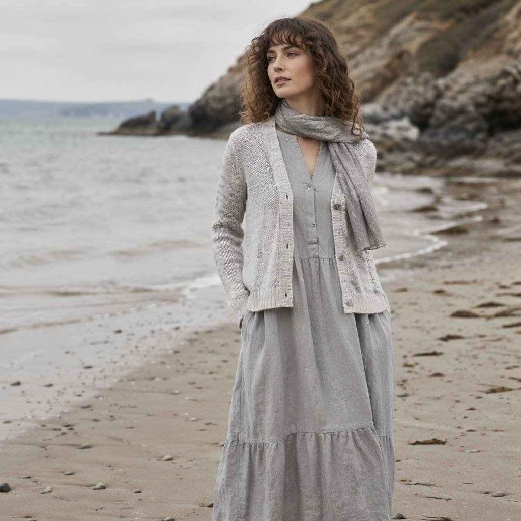 Editorial fashion model in Carol Wright women's clothing on a beach, cottagecore styling, cool gray palette, natural pose.