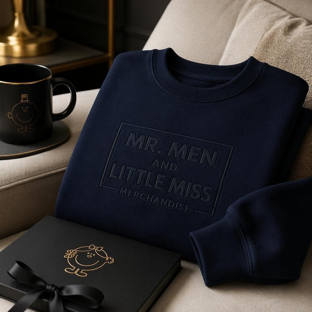 Photo-real navy crewneck mockup in a cozy luxury home setting with subtle tone-on-tone mr men and little miss merchandise logo.