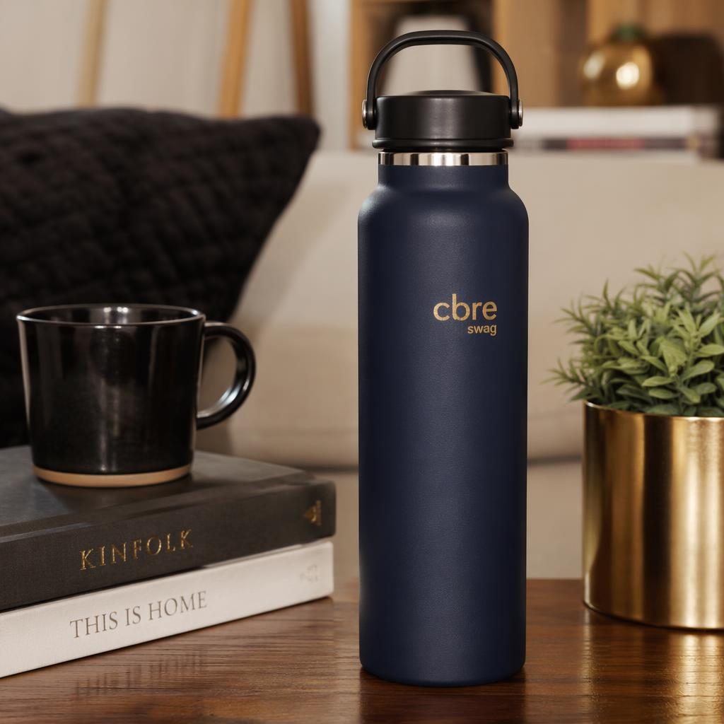 Photo-real navy water bottle mockup with small cbre swag logo, styled in a cozy home scene with black and gold accents.