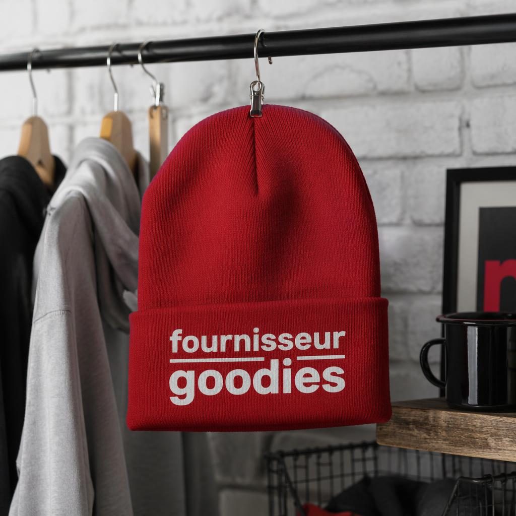 Bonnet rouge classique suspendu sur un portant, avec logo typographique générique en grand, photo studio nette.