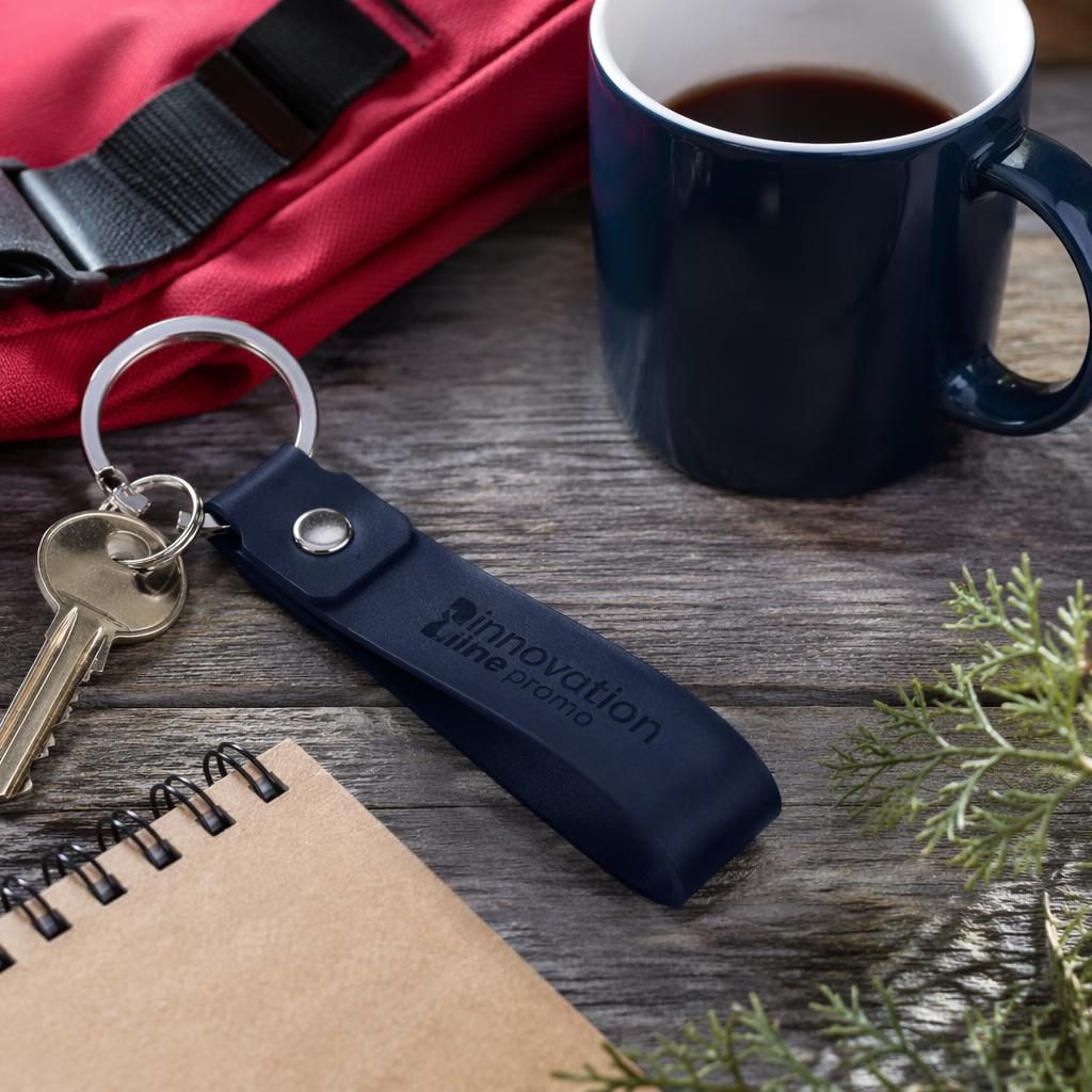 Photo-real navy keychain mockup outdoors with subtle tone-on-tone innovation line promo logo, sharp texture