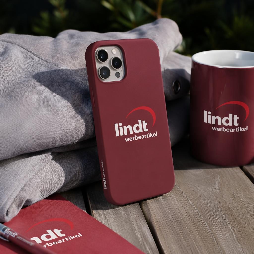 Fotorealistisches Mockup einer bordeauxroten Handyhülle mit lindt werbeartikel Logo im Outdoor-Lifestyle-Stil
