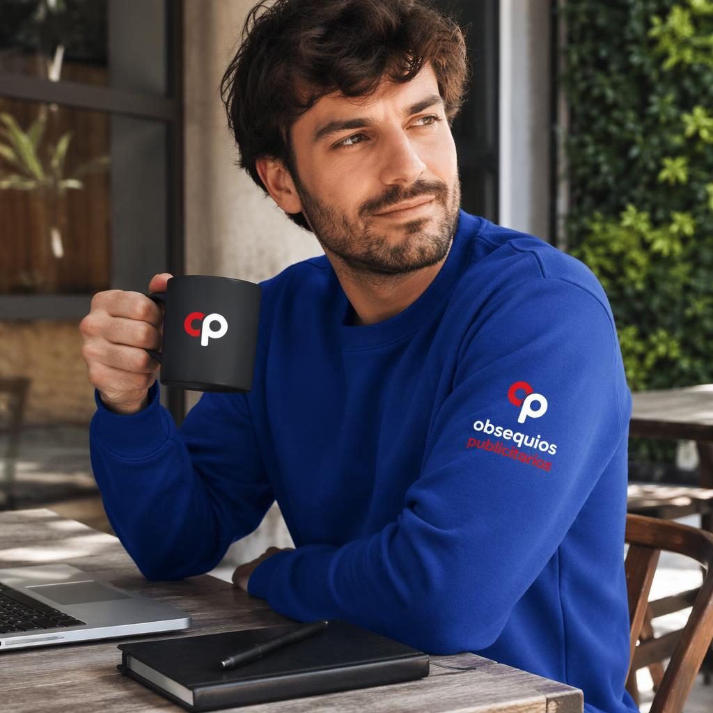 Sudadera azul royal de cuello redondo con logo genérico en la manga, fotografiada al aire libre con estilo lifestyle.