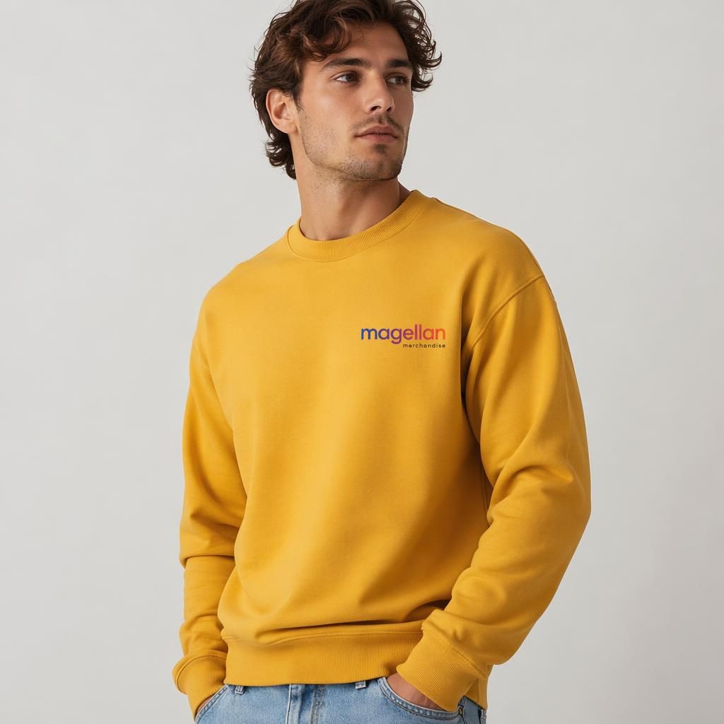 Model wearing a mustard yellow crewneck with a small magellan merchandise logo on the left chest in studio lighting