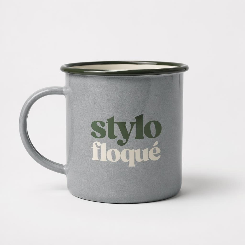 Mug émaillé gris chiné sur fond blanc, logo sage et ivoire au dos, photo studio nette et minimaliste