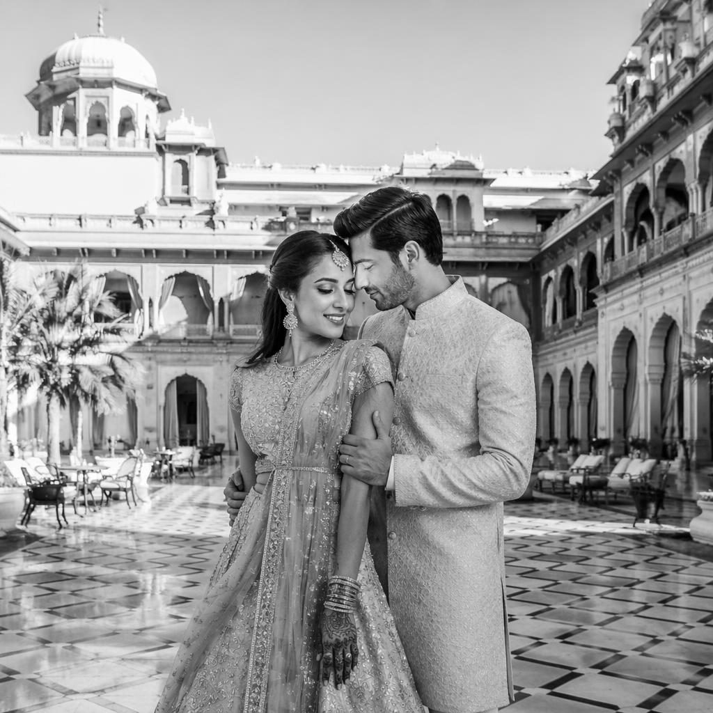 Black and white wedding portrait of a couple in a palace courtyard during winter, editorial style with natural light.